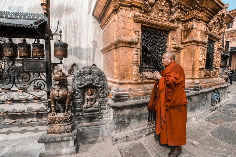 a monk looks out of his doorway on a stone building