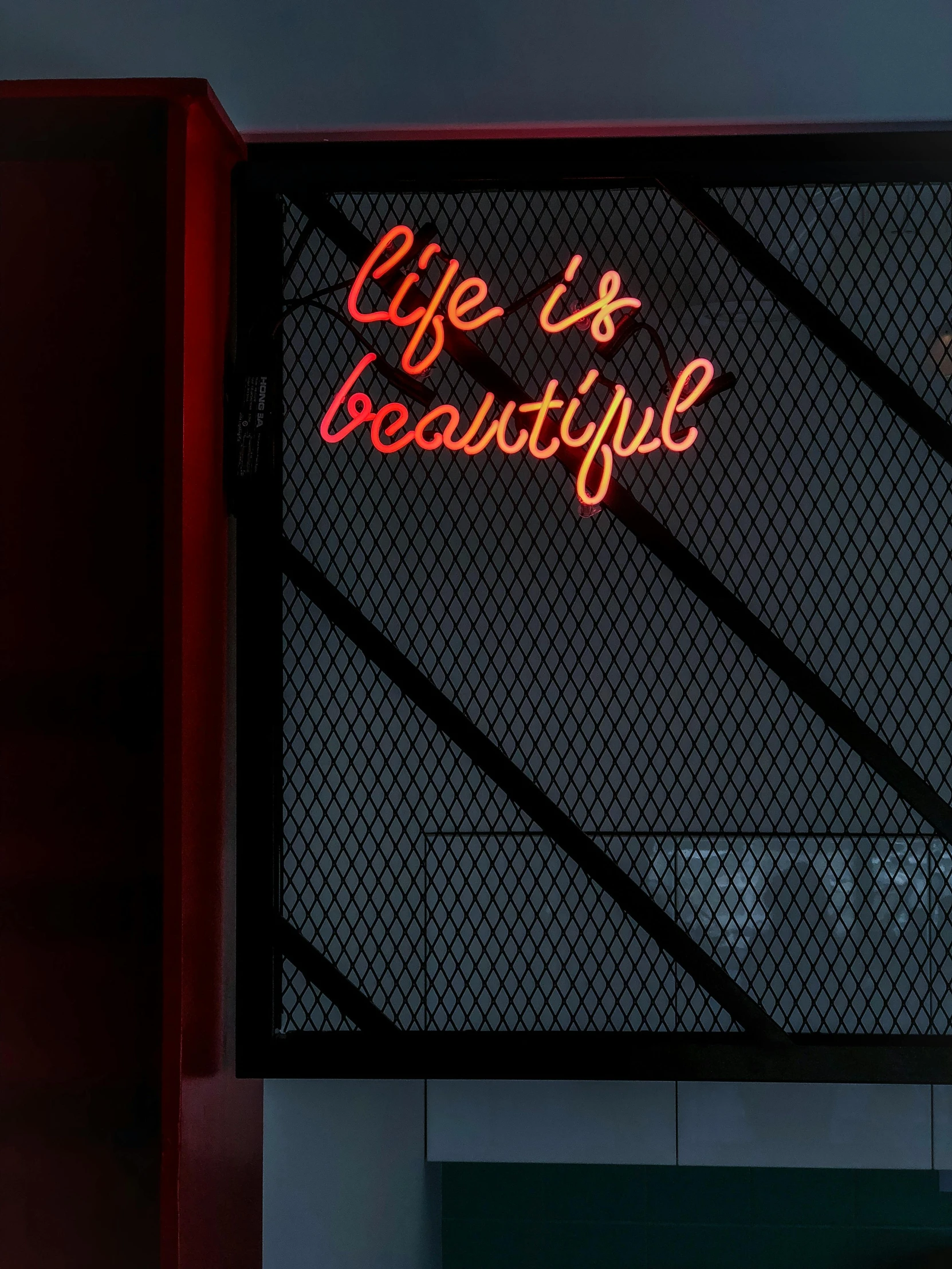 a neon sign reads life is beautiful and an open window