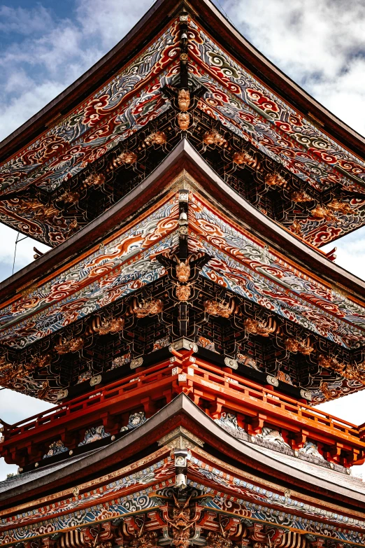 the top of a tall pagoda against a cloudy sky