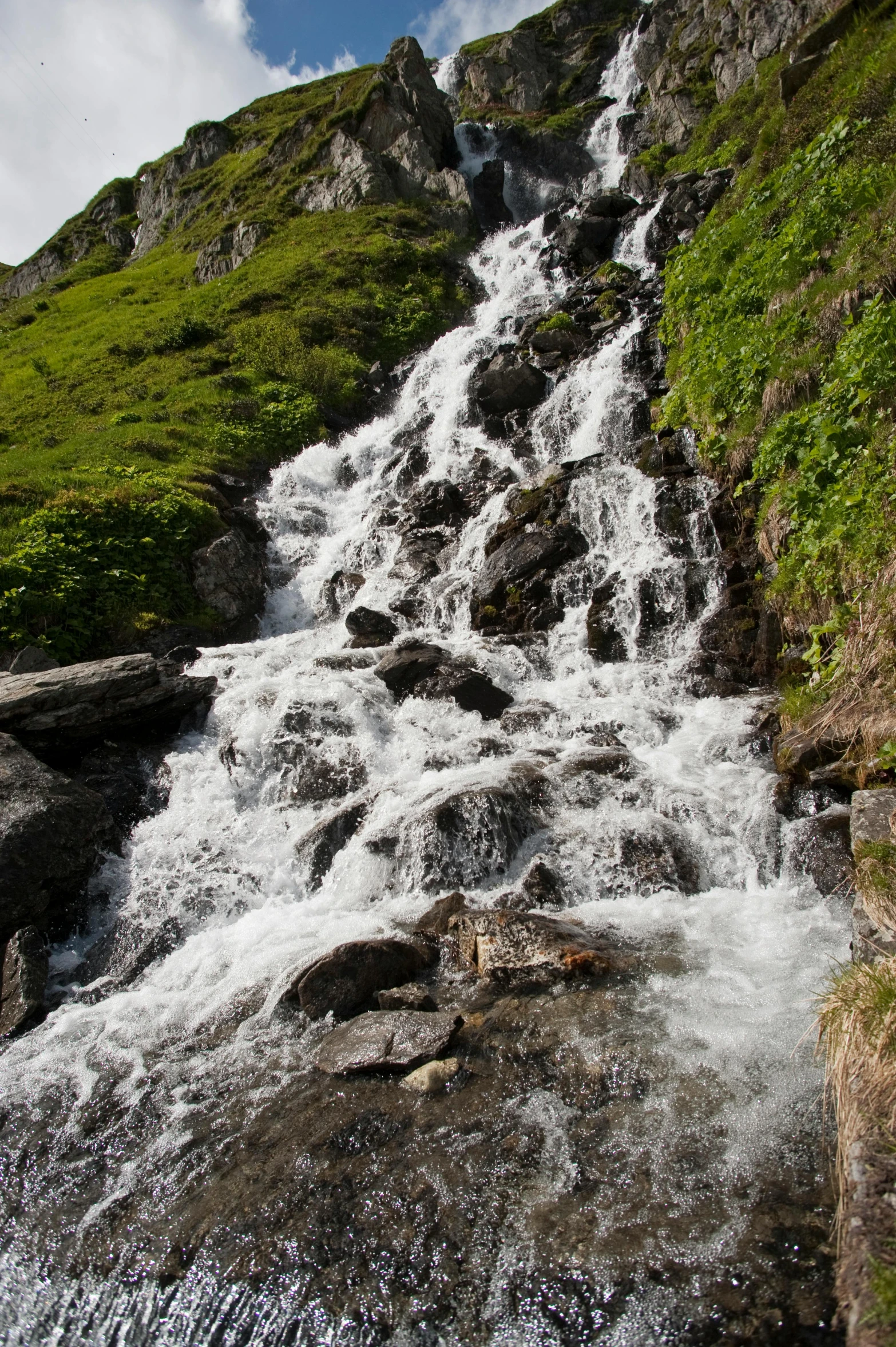 a small waterfall surrounded by rocky hillside sides