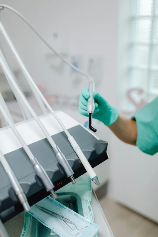 a woman holding a medical needle and in green gloves