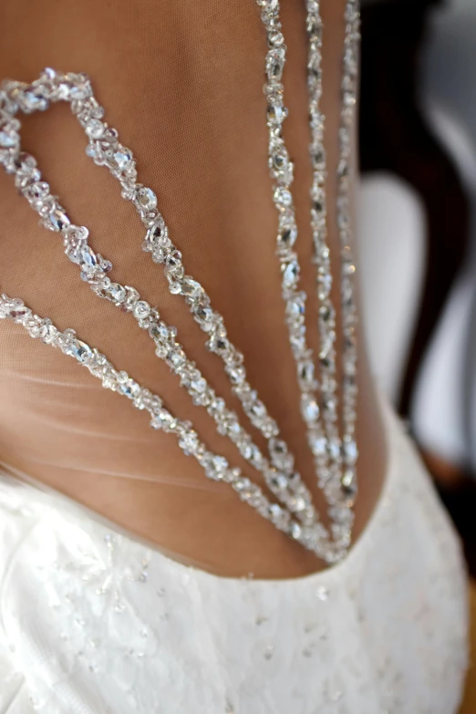 a bride wears crystaled bridales and a veil