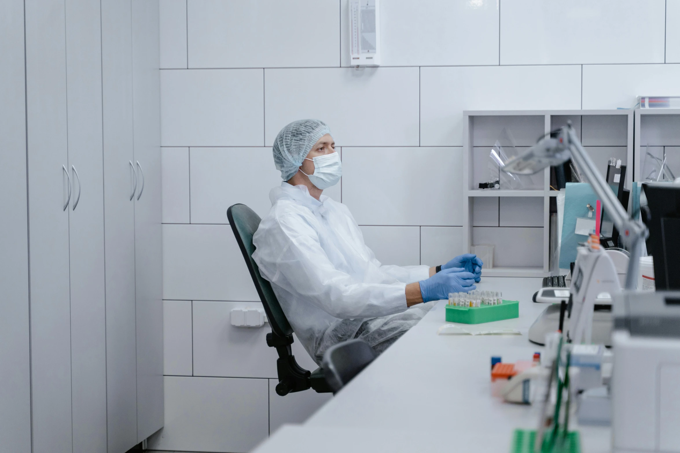 a man in a white lab coat and surgical mask