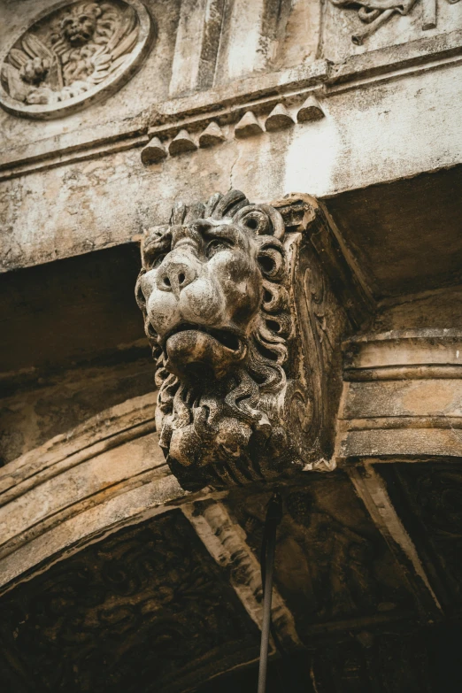 a stone statue on a wall with a decorative face