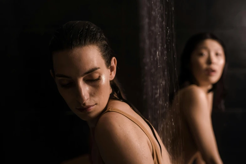 a  woman standing next to a shower head