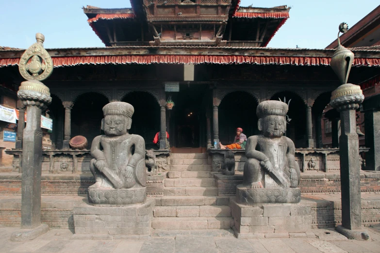 statues standing at the entrance to a temple