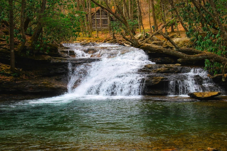 there is a waterfall in the woods near the river