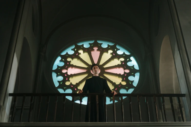 a stained glass window inside a cathedral with a man standing behind it