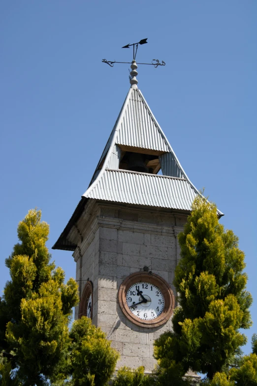 a building has a clock and weather vane on it