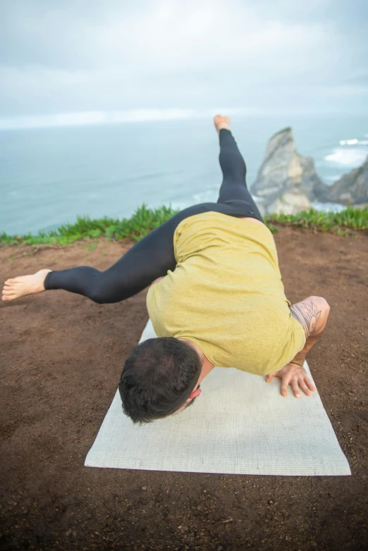 a person is doing yoga on top of the sand