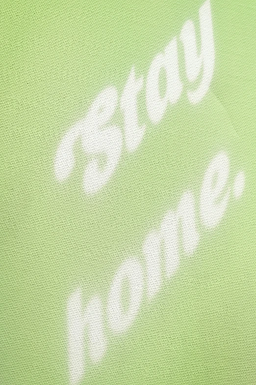 the back side of a green shirt with white writing