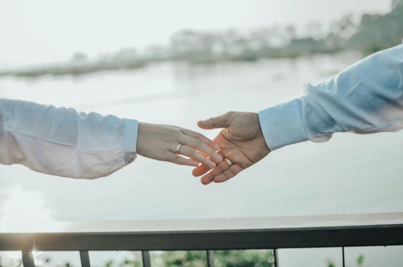 two people reaching out their hands in the air