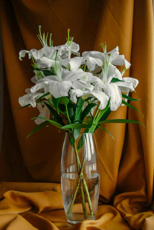 a glass vase with some white flowers on it