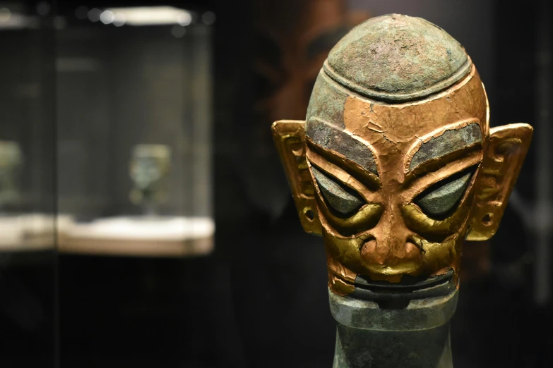 an ornate bronze head with a large nose