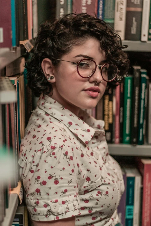 the woman is wearing glasses near many books