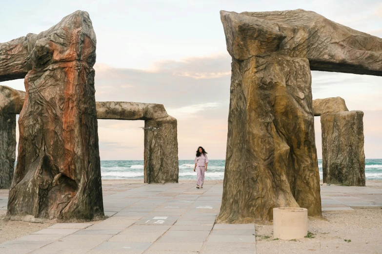 a girl is standing in between two large rock formations