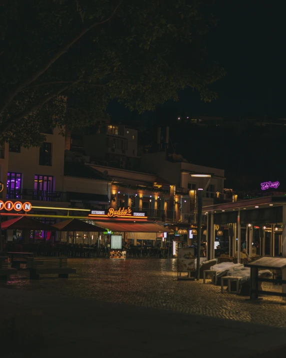 a few benches and tables next to a street