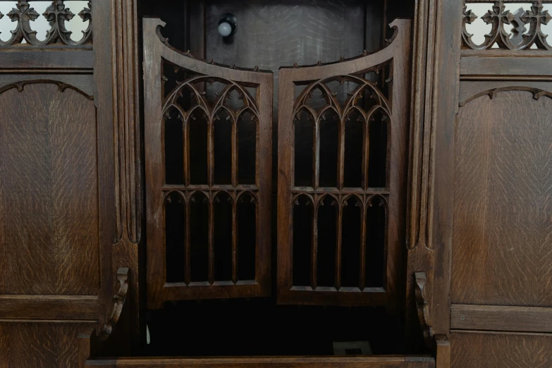 a very ornate wooden cabinet with the doors open