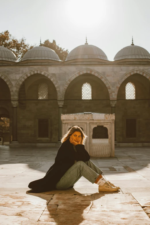 the woman is sitting alone in a courtyard area