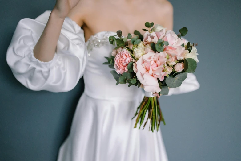 a bride in a white dress holding a bouquet