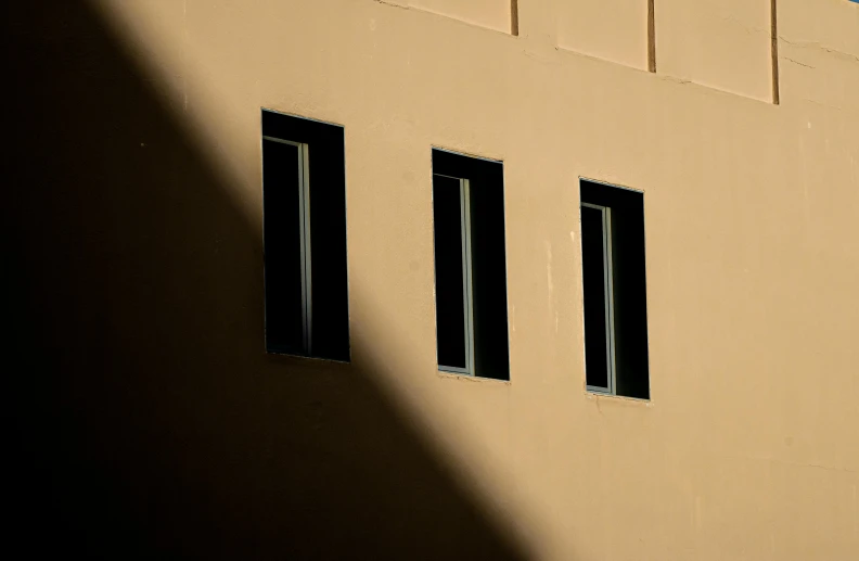 a tan building has three windows on each side