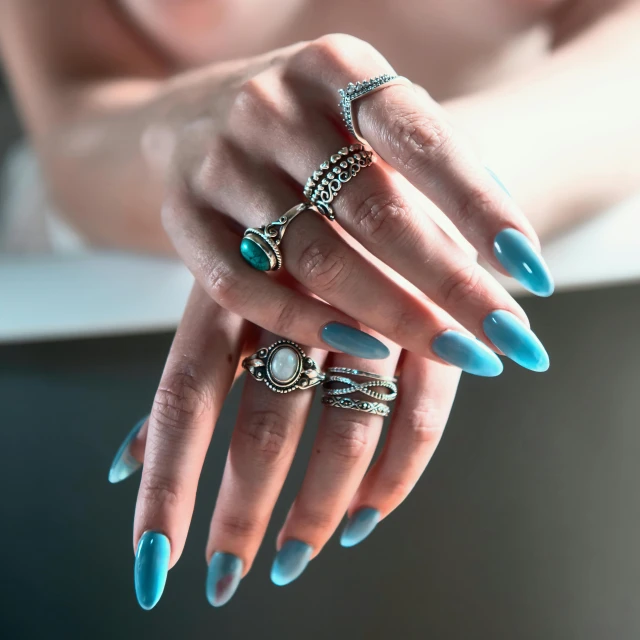 woman with blue nail polish holding rings in her hands