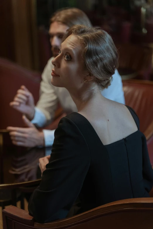 a woman in a dress sitting in a chair looking up