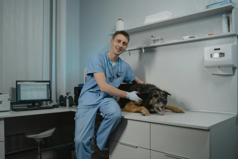 there is a male in scrubs sitting with a dog