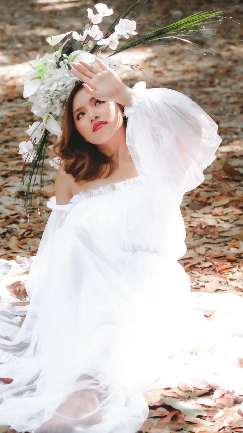 a woman sitting on the ground next to leaves