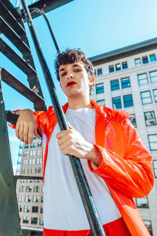 young man dressed in red and white posing with the street sign