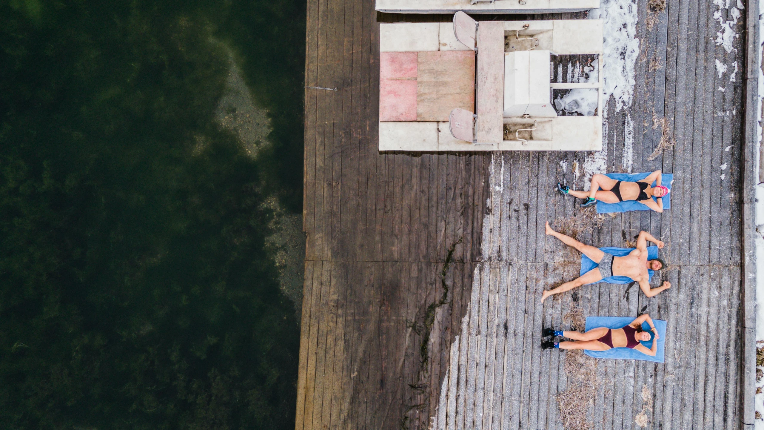 a few girls are standing near the edge of a pier