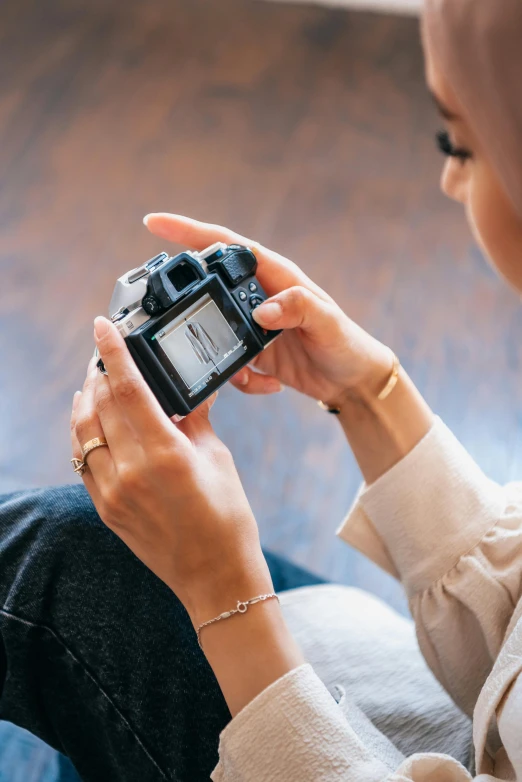 a woman using her digital camera sitting on a couch