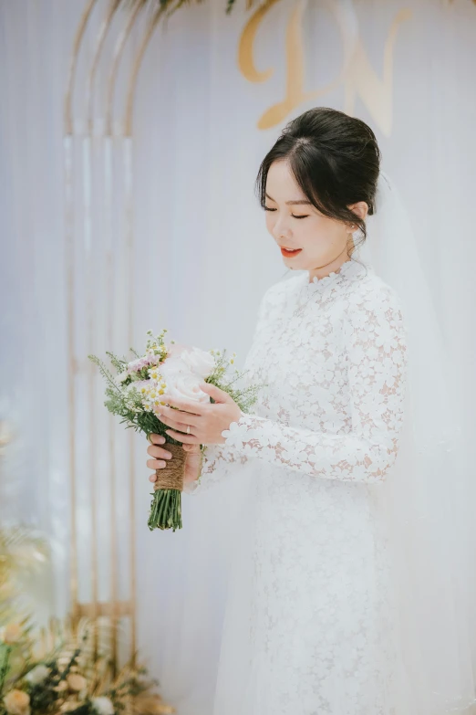 a woman in white wearing a wedding gown holding a bouquet of flowers