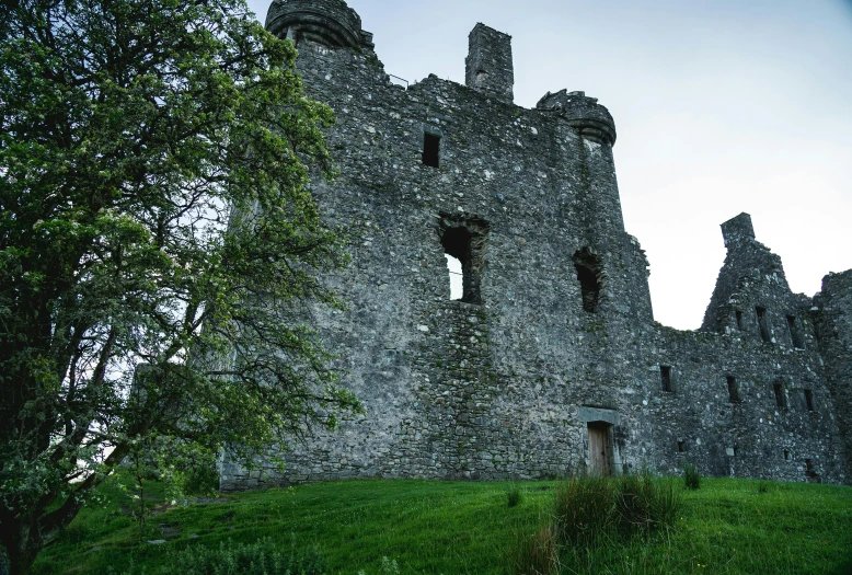 a stone castle sitting on top of a lush green field