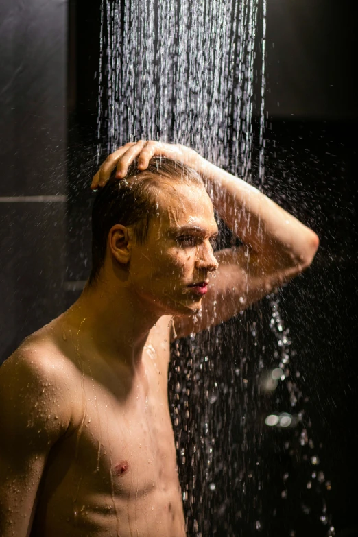 young man standing in shower, wearing  on