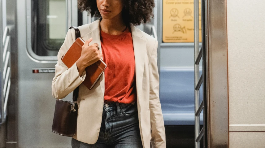 a woman with an afro walking down a train platform