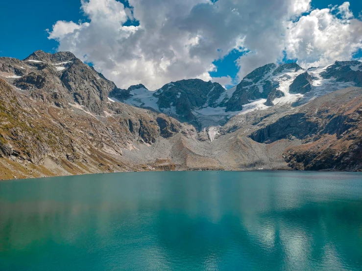 a beautiful mountain lake with clouds over the mountains