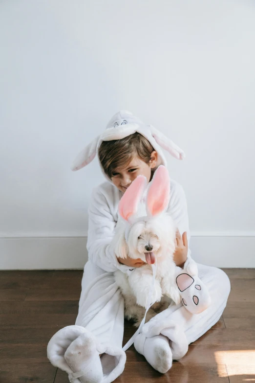 a girl dressed in bunny costumes and holding a dog