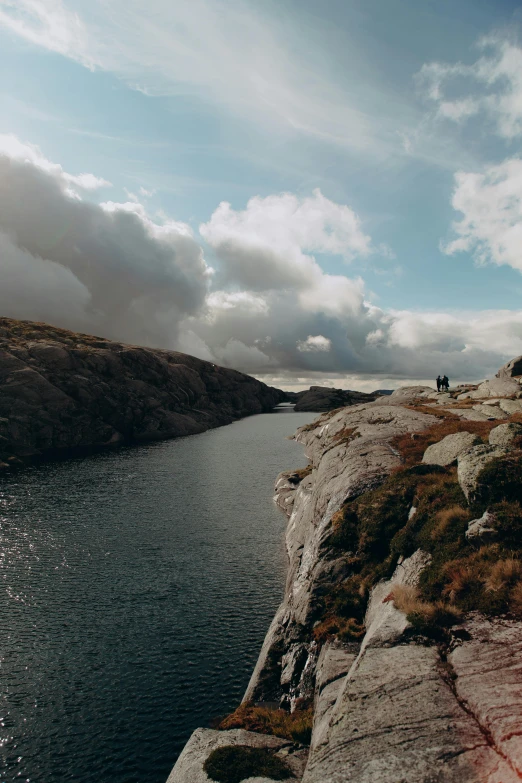 some people on a hill near a large body of water