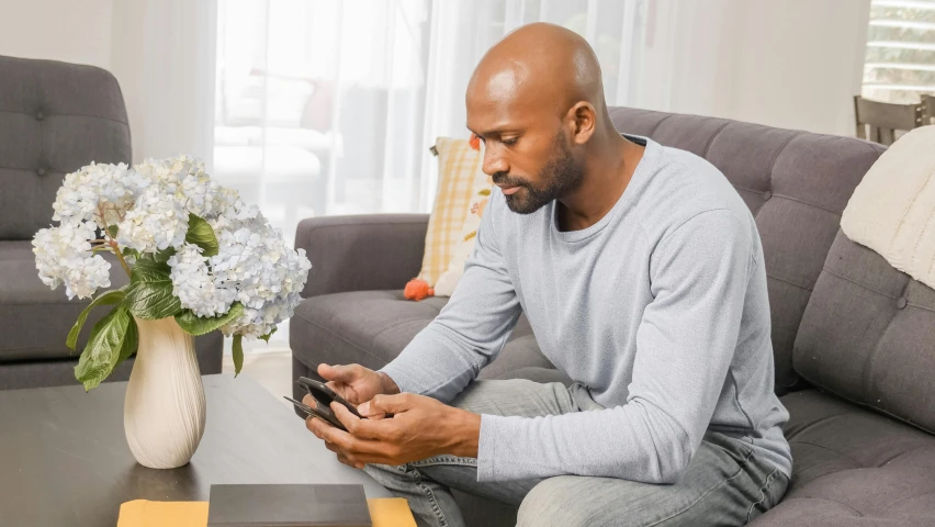 a man sitting on a couch using his phone