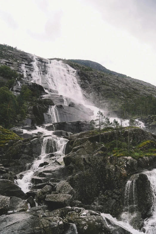 a very tall waterfall surrounded by small rocks