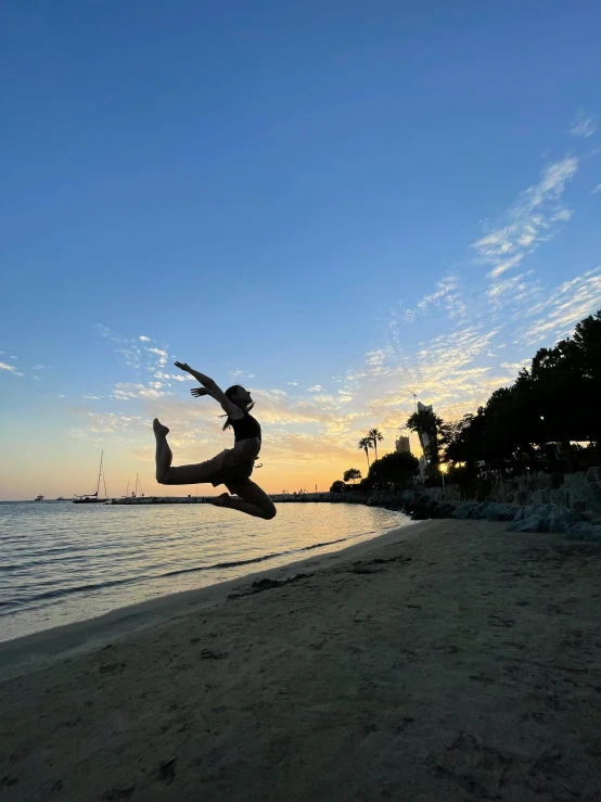 a person is performing an aerial stunt on the beach