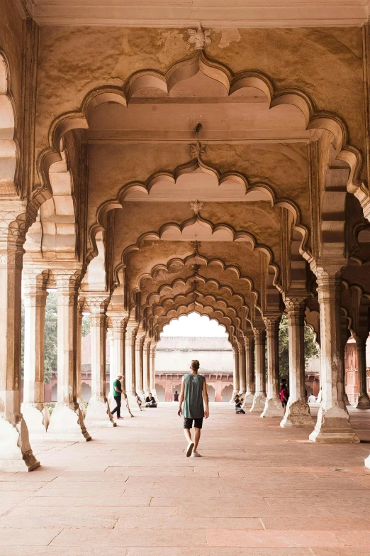 a man walks under a huge brick and stone structure