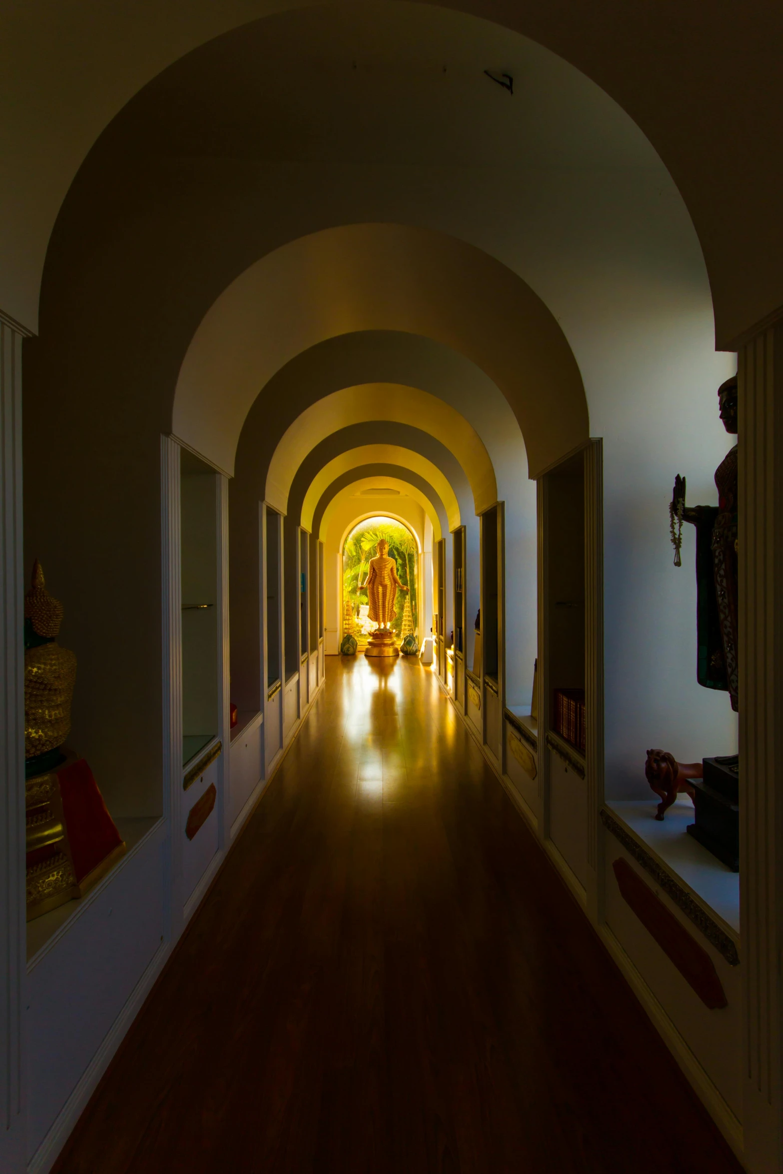 a dimly lit hallway with a long archway
