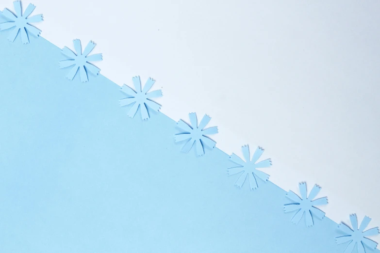 blue paper snow flakes are placed on the blue surface