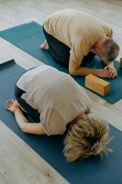 two men on yoga mats in the middle of a room