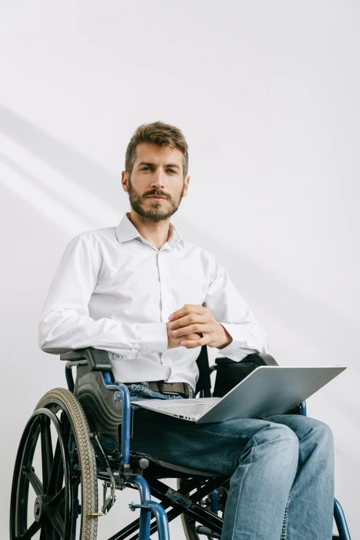 a man sitting in a wheelchair with a laptop