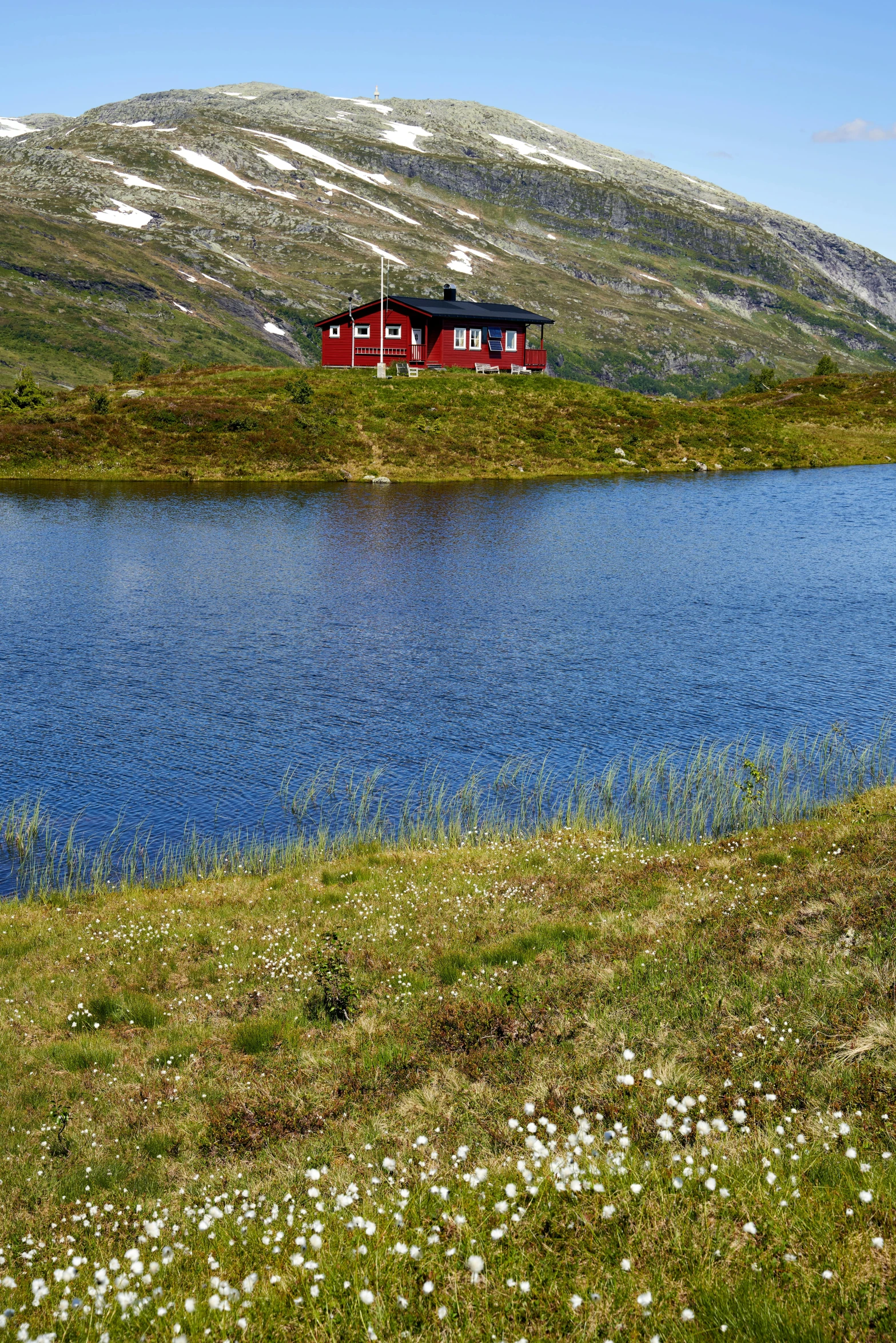 a red house near the edge of a lake