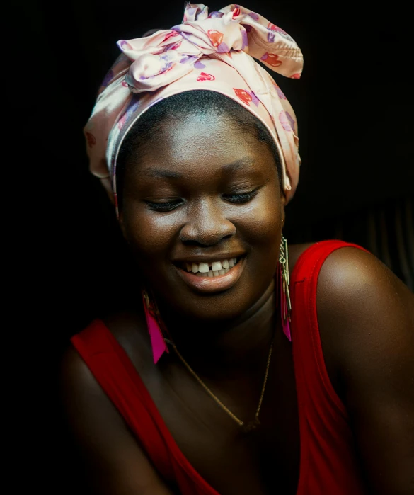 woman wearing a flowered head wrap smiles broadly