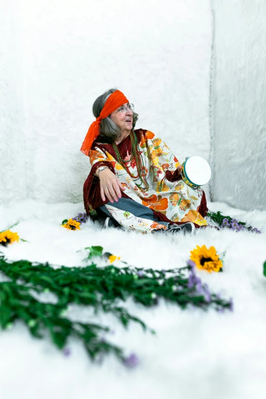 an old man sitting on the ground with a hat